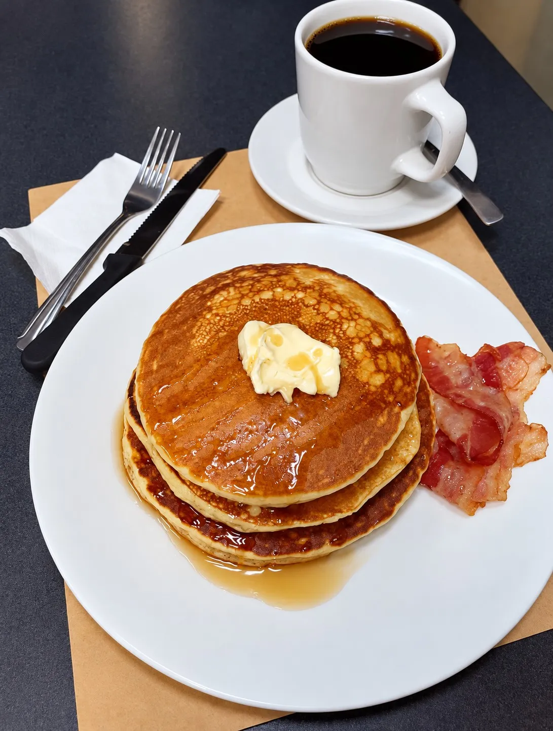 Pancakes with butter, bacon and coffee